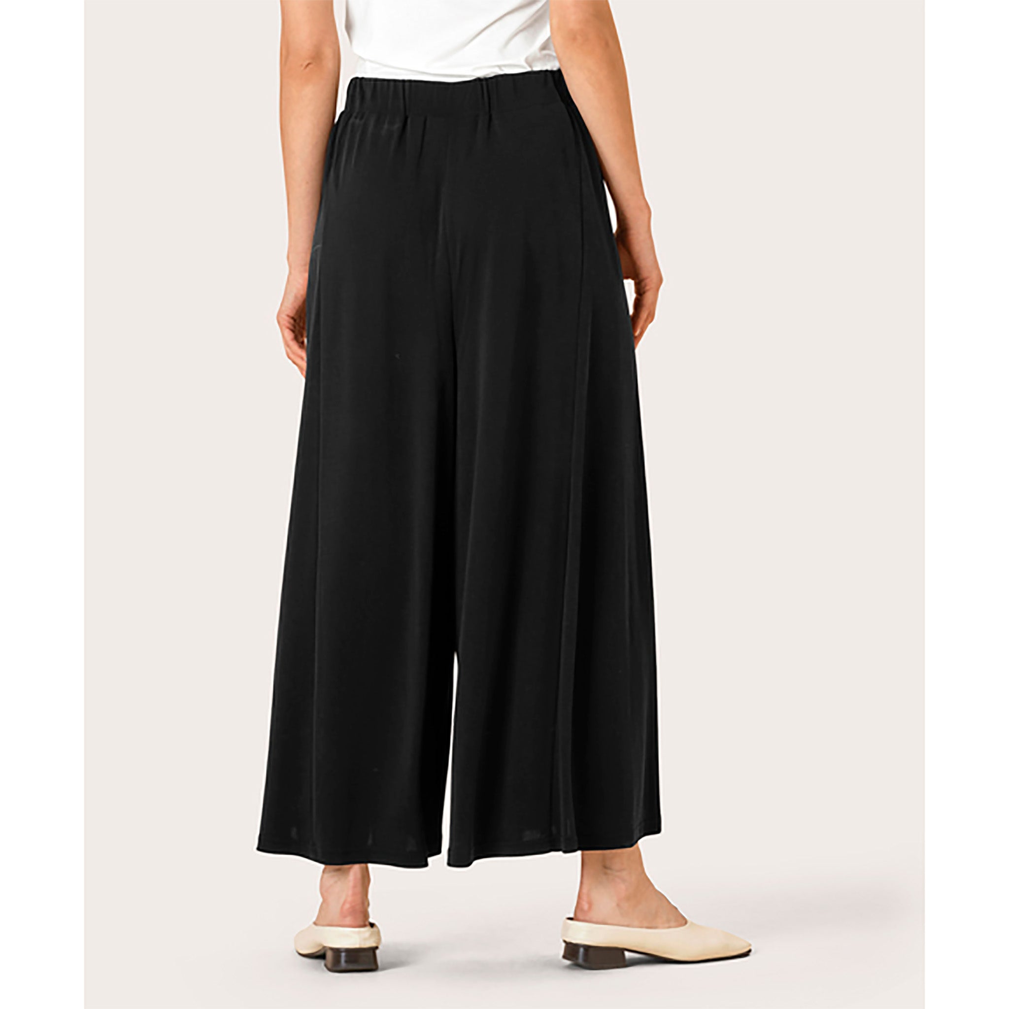 Masai. Mustat, vajaamittaiset, erittäin leveät housut / housuhame. Takakuva mallin päällä.