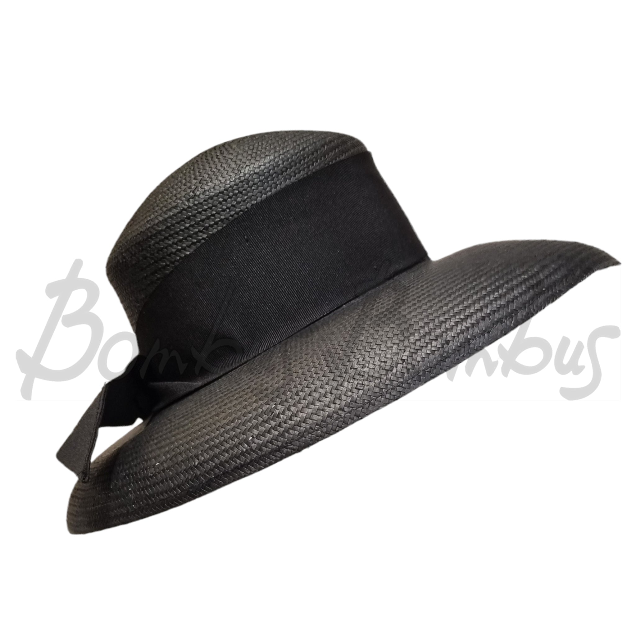 Kati Niemi, musta, leveälierinen hattu. Hatussa on leveä musta ripsinauha ja rusetti. Sivukuva.